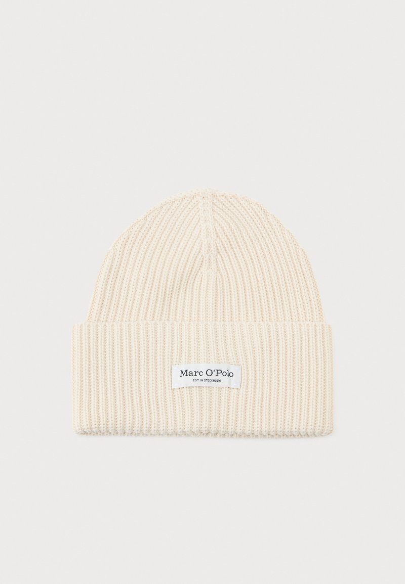 Berretto a maglia color crema con una trama a coste. Presenta un risvolto e un'etichetta del marchio cucita sulla parte anteriore. Leggero e flessibile.