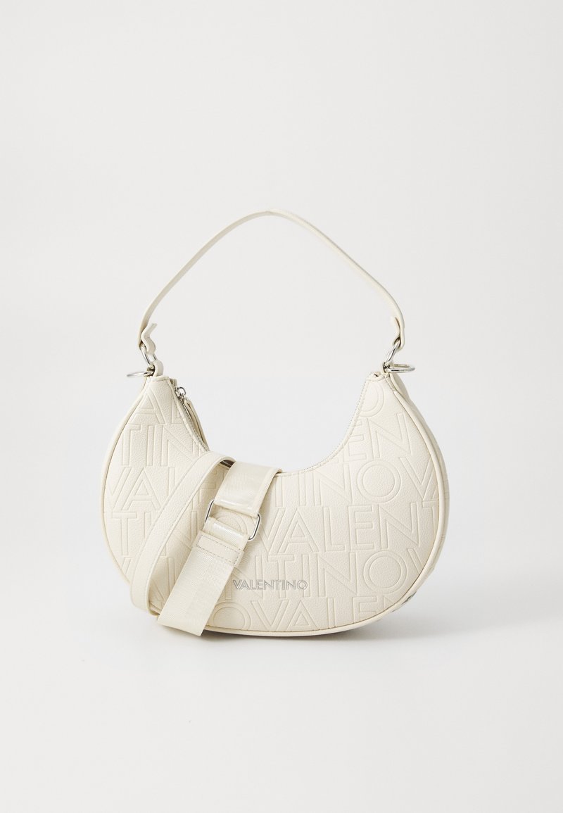 Cream-colored crescent-shaped handbag made of textured material, featuring embossed logo, adjustable strap, and silver hardware accents.