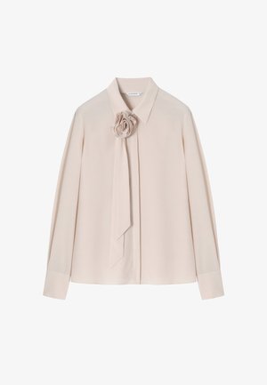 Heled roosat pluusi, millel on struktureeritud krae ja pikad varrukad. Sellel on dekoratiivne roosi detail ja kaeluses seotud kangariba.