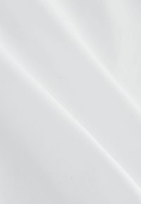 Tissu blanc à la texture lisse, présentant de subtils plis et un éclat qui reflète la lumière, affichant une esthétique propre et monochromatique.