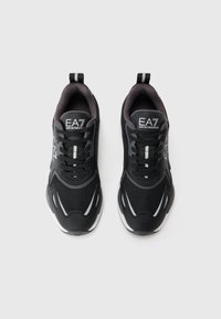 Zwarte sneakers van mesh en synthetische materialen, met witte accenten en veters, een afgeronde neus en een pull tab aan de hiel.