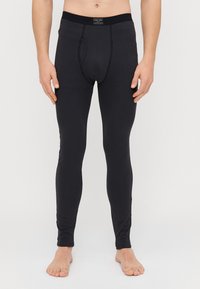 Leggings noirs en matériau lisse et extensible. Présente un design ajusté et une taille avec une marque. Pas de motifs ou accents notables.