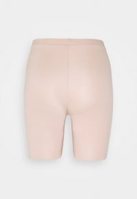 Lichtroze stretchshorts, hoog in de taille, gladde textuur, geen zichtbare naden, ontworpen om strak te passen. Eenvoudige stijl zonder versieringen.
