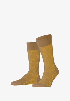 Beige knielange Socken mit geripptem Bund, die ein durchgängiges gelbes Paisleymuster aufweisen und eine glatte Textur haben.