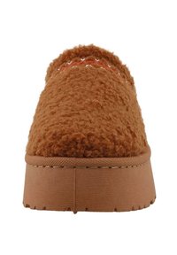 Bruine, fuzzy slipper met een gestructureerde bovenkant, een vlakke platformzool en decoratieve rode stiksels aan de voorkant. Zacht en gezellig uiterlijk.