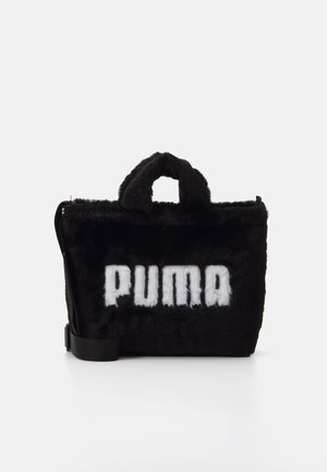 Czarna futrzana prostokątna torebka z krótkimi uchwytami i regulowanym paskiem na ramię, z białym napisem "PUMA" z przodu.