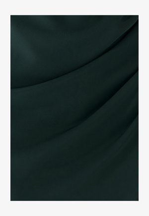 Dunkelgrüner Stoff mit glatten, fließenden Falten, die die Textur und subtile Lichtreflexionen betonen.