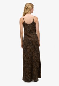 Vestido maxi de tela ligera con estampado de leopardo en tonos marrón y negro, con finos tirantes y escote redondo en la espalda.