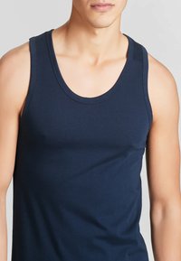 Top in cotone elastico blu navy, con scollatura rotonda e spalline larghe. Texture liscia con un design semplice.