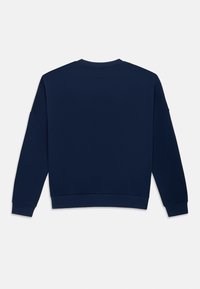 Bluză simplă, albastru marin, cu mâneci lungi, cu manșete și tiv striate, văzută din spate pe un fundal alb.