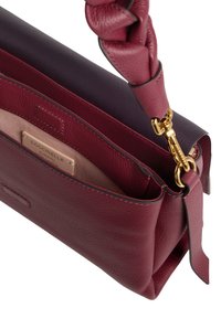 Borsa in pelle rosso scuro con manico intrecciato, chiusura dorata e etichetta interna che recita "Coccinelle Pelle Italiana Autentica."