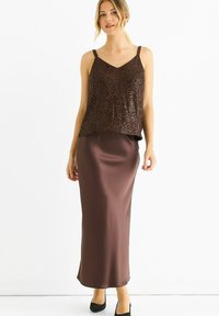 Brown sequined camisole top paired with a satin chocolate brown maxi skirt, featuring a smooth texture and adjustable straps.
