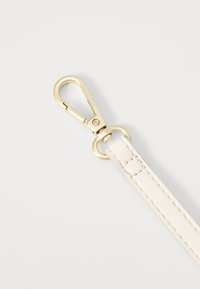 Hvid læderrem med syninger, der har en guldfarvet metal swivel snap hook til fastgørelse. Glat tekstur og minimalistisk design.