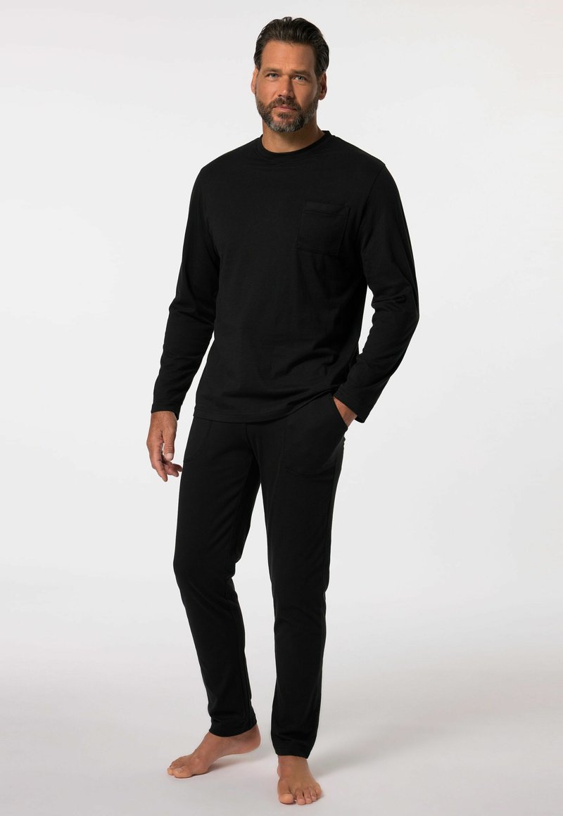 Haut noir à manches longues avec une poche sur la poitrine, associé à un pantalon noir assorti. Les deux vêtements sont fabriqués dans un tissu doux et confortable.