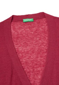 bordó svetr s výstřihem do V, strukturovaná pletenina a štítek označený "United Colors of Benetton" na výstřihu.