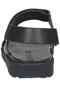 Sandale en cuir noir avec un footbed contourné, des sangles ajustables, un design perforé et une semelle épaisse et texturée. Taille 42 marquée à l'intérieur.
