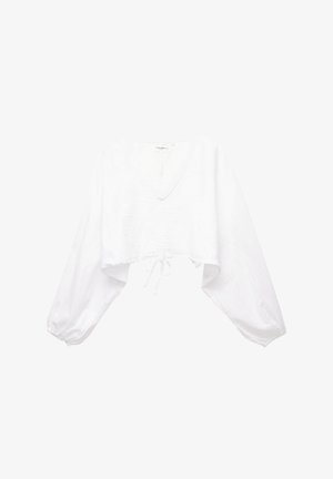 Blouse blanche courte avec un large col en V, des manches longues amples, un cordon de resserrage à l'ourlet et un tissu texturé.