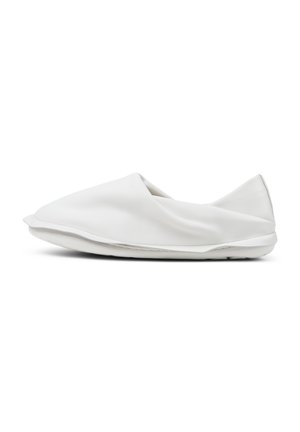 Scarpa bianca senza lacci realizzata in pelle liscia. Presenta un design minimalista con una forma arrotondata e una suola piatta, scelta per il comfort e la facilità d'uso.