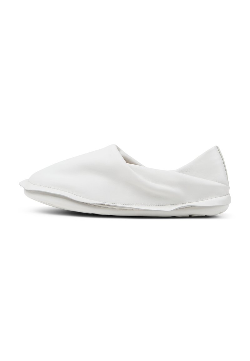 Scarpa bianca senza lacci realizzata in pelle liscia. Presenta un design minimalista con una forma arrotondata e una suola piatta, scelta per il comfort e la facilità d'uso.