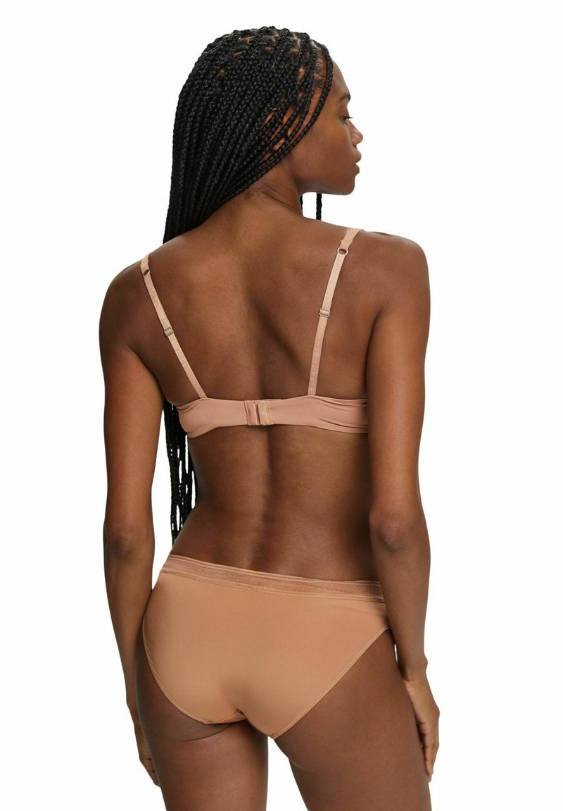 Nude-Bikini-Set mit verstellbaren Trägern, Hakenverschluss und einem glatten, nahtlosen Design. Der Stoff hat ein mattes Finish ohne Muster.