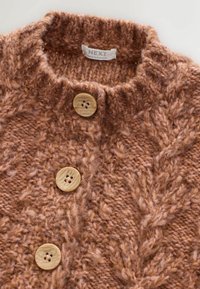Sweter kardigan w ciepłym brązie z warkoczowym splotem, z trzema dużymi, okrągłymi beżowymi guzikami oraz miękkim, grubym wzorem z włóczki.