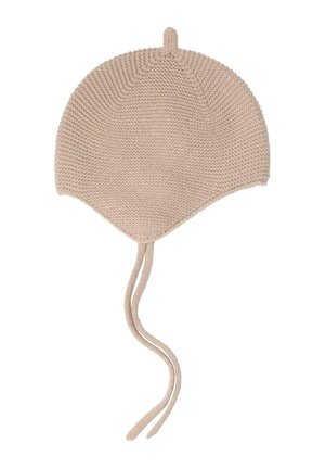 Beige strikket babyhue med øreklaffer og to lange snore hængende foran.
