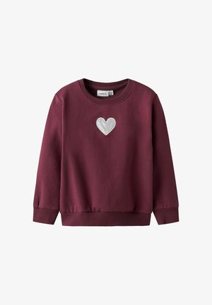 Burgundowa bluza z okrągłym dekoltem i długimi rękawami, z metaliczną aplikacją serca z przodu. Gładki, miękki materiał.