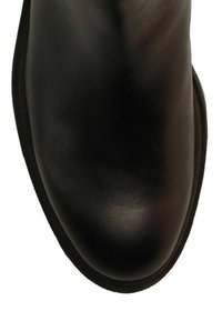 Zwarte lederen schoen met een ronde neus en een zwarte zoolrand, getoond vanuit een bovenaanzicht op een witte achtergrond.