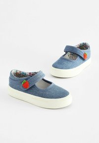 Chaussures en denim bleu avec une sangle et un petit accent de fraise rouge. Tissu texturé, semelles en caoutchouc blanches et doublure intérieure à motif floral.