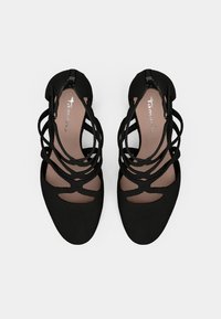 Ζευγάρι μαύρα πλατφόρμα σανδάλια με λουράκια, κλειστές στρογγυλεμένες μύτες και φερμουάρ στην πλάτη, εμφανίζονται από πάνω σε λευκό φόντο.