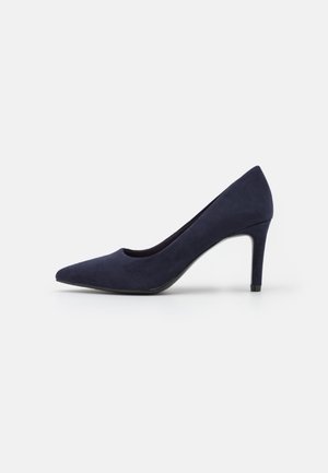 Mørkeblå ruskinds højhælet sko med spids tå og en slank mellemhøj hæl på en hvid baggrund.