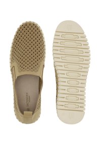 Zapatos slip-on beige con parte superior texturizada que presenta un diseño ondulado. Suela de goma flexible con patrones de dibujo distintos. Marca mínima en el interior.