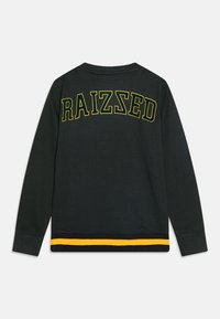 Sudadera negra de manga larga con "RAIZED" impreso en amarillo en la parte posterior. Cuenta con una franja amarilla en el dobladillo y puños acanalados.