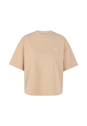Beige übergroßes T-Shirt mit kurzen Ärmeln, kleinem Herz-Emblem auf der linken Brust und rundem Halsausschnitt.