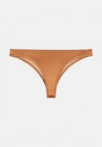 String en teinte chair en matériau lisse avec une taille basse et un design minimaliste. Présente un panneau transparent sur les côtés.