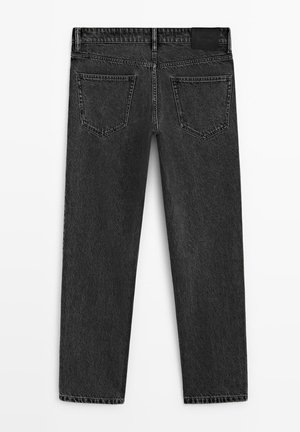 Schwarze Denim-Jeans flach ausgelegt, die Rückseite mit zwei Gesäßtaschen, Gürtelschlaufen und einem Etikett am Bund auf einem schlichten weißen Hintergrund.