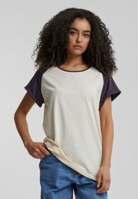 Kortærmet t-shirt i creme og marineblå farveblok lavet af blødt stof. Har en rund halsudskæring og en afslappet pasform, med optrukne ærmer.