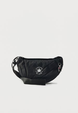 Black nylon sling bag with circular design, white logo, and an adjustable strap. Features a zip closure and a small star accent.