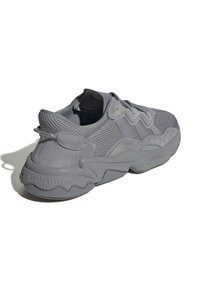 Sneaker grigia caratterizzata da un mix di materiali traspiranti in mesh e materiali lisci, progettata con una suola chunky e dettagli testurizzati per una presa migliore.