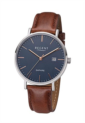 Montre ronde avec un boîtier en acier inoxydable, un cadran bleu foncé, des index en or rose et une fonction date. Elle est dotée d'un bracelet en cuir marron avec des coutures.