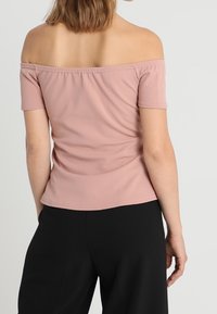 Růžový top bez ramínek s krátkými rukávy, vyrobený z měkké látky, s nařaseným výstřihem a slim fit střihem.