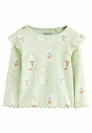 Lichtgroene ribbeltop met lange mouwen, voorzien van ruches aan de mouwen, bloemen- en konijnprints, een gegolfde zoom en kleine gouden accenten.