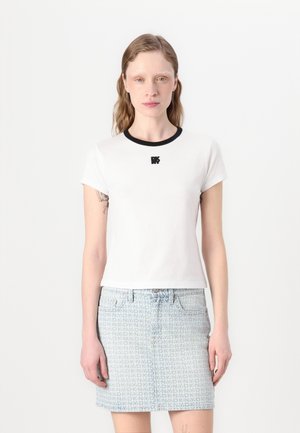 Hvid t-shirt med korte ærmer, sort ribbet halsudskæring og lille sort logo på brystet, sat sammen med en lys blå denimnederdel med et geometrisk mønster.