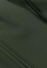 Donkergroene stof met een gladde textuur, gekenmerkt door fijne stiksels en subtiele plooien, die een lichtgewicht en flexibele design benadrukt.