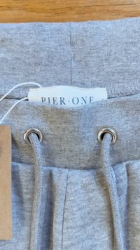 Grå bomullssweatpants med silver ögla, elastisk dragsko och en etikett som säger "PIER•ONE." Slät textur med en avslappnad design.