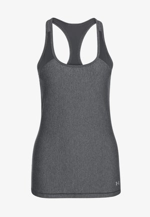 Vrouw in een grijze tanktop, zwarte legging met roze accenten en zwarte hardloopschoenen met roze veters, lopend tegen een effen lichte achtergrond.