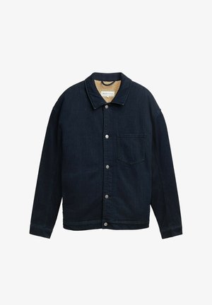 Tume teksajope kraega, ees nööpidega, ühe rinnataskuga ja tekstureeritud helepruuni voodriga. Omab lahtist lõiget.