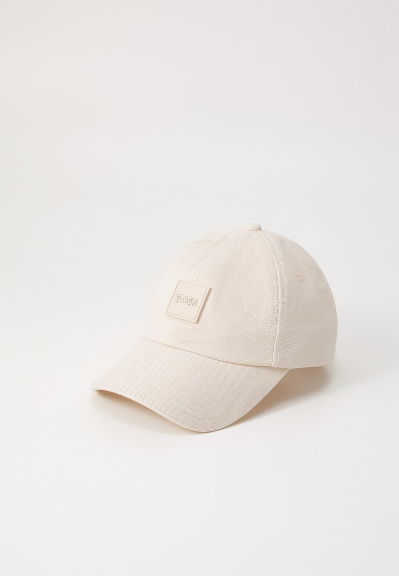 Beeži puuvillane pesapalli müts, millel on ümar kroon, kõver visor ja ruudukujuline logo märk "BOSS" ees.