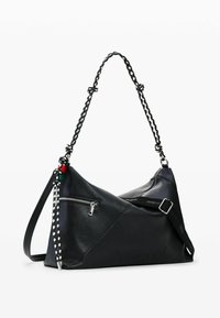 Mustast nahast käsikott geomeetrilise disainiga, mis sisaldab lukuga taskut, punutud rihma ja reljeefset kaubamärgi logo.