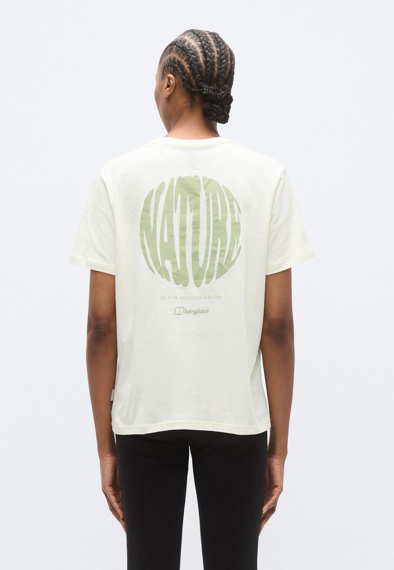 Κοντομάνικη μπλούζα σε κρεμ απόχρωση με πράσινο κείμενο που γράφει «NATURE» και «ΕΙΝΑΙ Η ΓΕΙΤΟΝΙΑ ΜΑΣ» στην πλάτη· άνετη εφαρμογή.